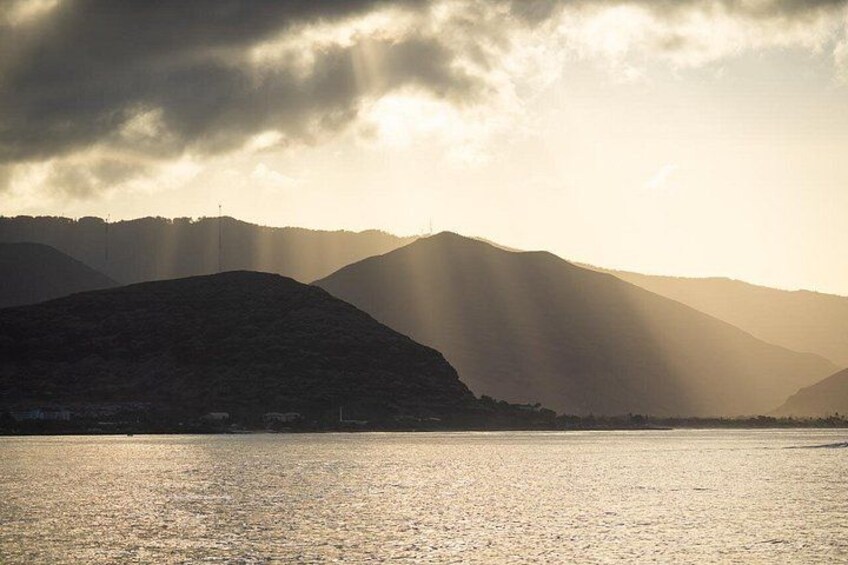 A mountainous landscape with a body of water reflecting sunlight. 3