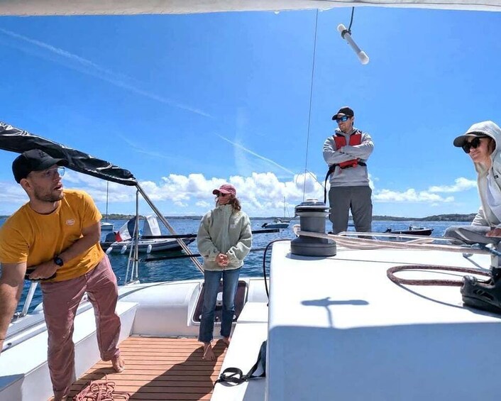 A group of people on a sailboat with a clear sky and calm sea in the background. 5
