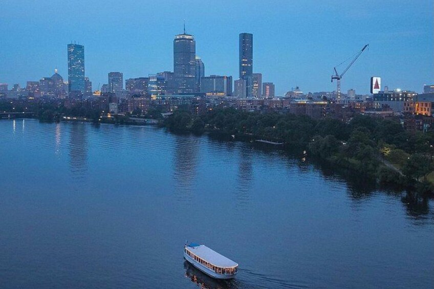A river with a boat, a city skyline with modern buildings, and a crane in the distance. 3