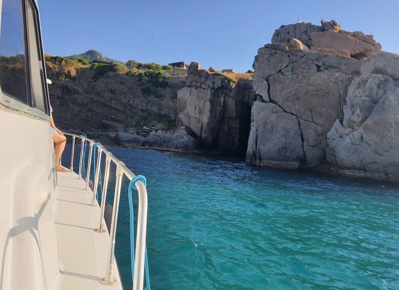 A boat navigating near rocky cliffs with clear blue water. 5