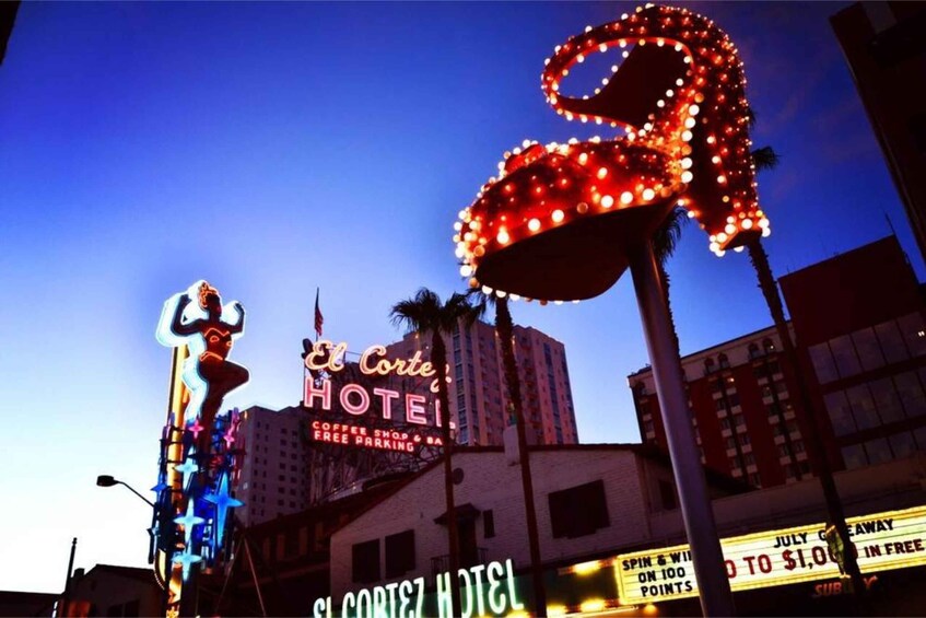 The El Corte Hotel with neon signs and a large illuminated sculpture. 2