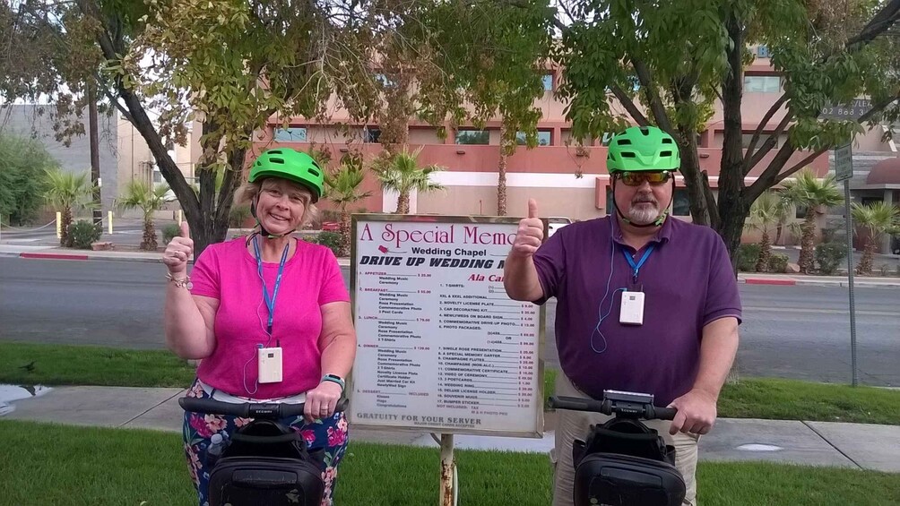 Two people on bicycles with a wedding menu sign in the background. 5
