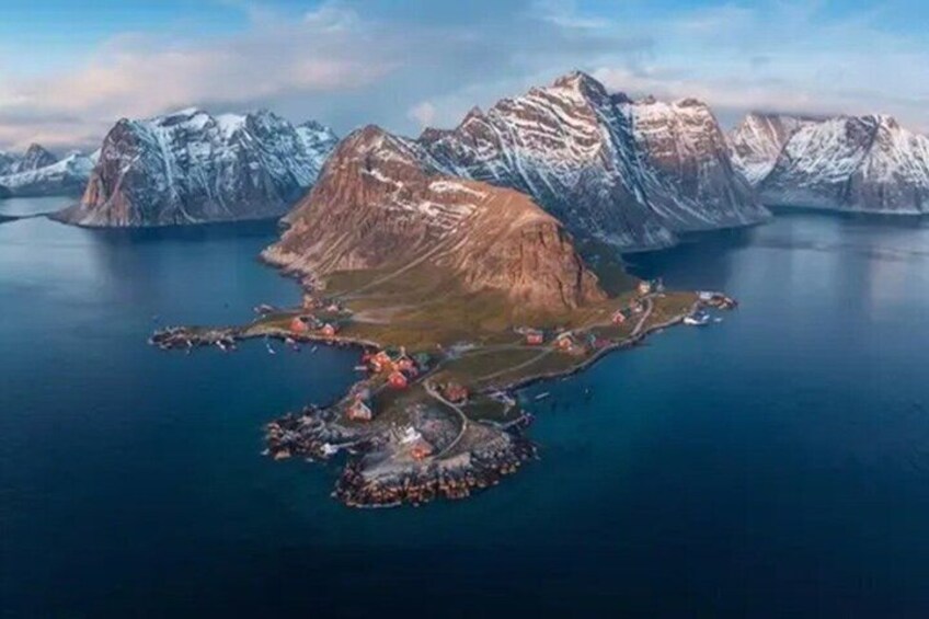 A coastal landscape with a prominent mountain range and a small settlement with buildings and boats. 3