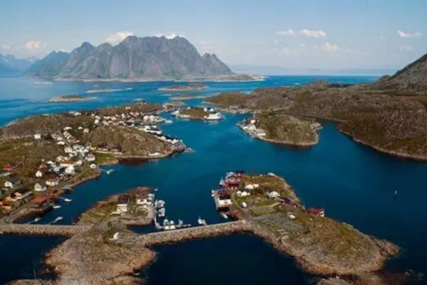 A coastal town with houses and boats, surrounded by water and mountains. 2