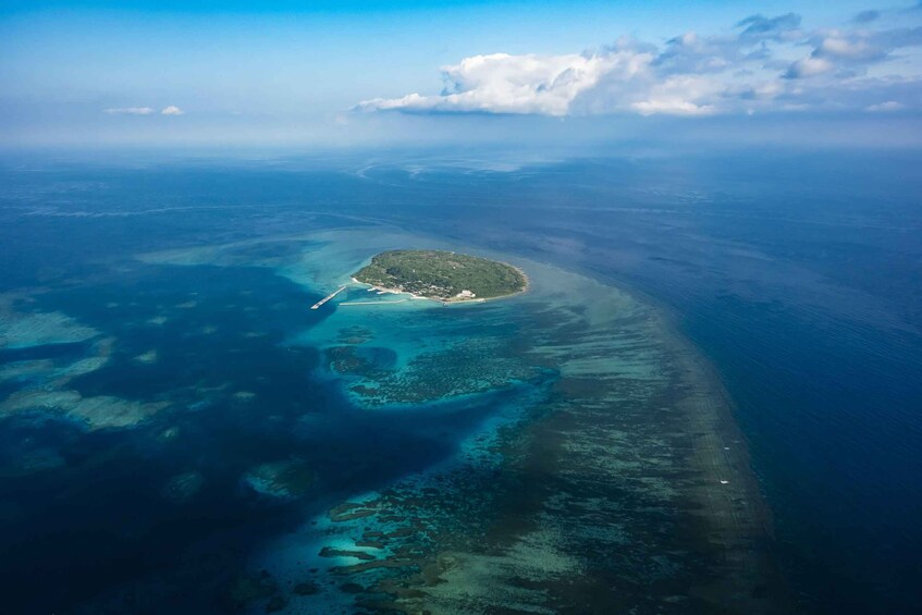 An aerial view of a tropical island with clear waters and a narrow beach. 3