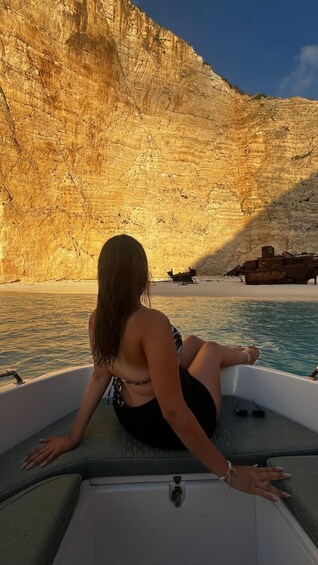 A woman on a boat facing a rocky cliff. 1