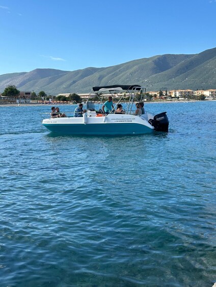 A boat with people on it, water, and mountains in the background. 5