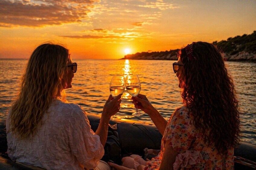 Two people toasting with wine glasses against a sunset over the sea. 1