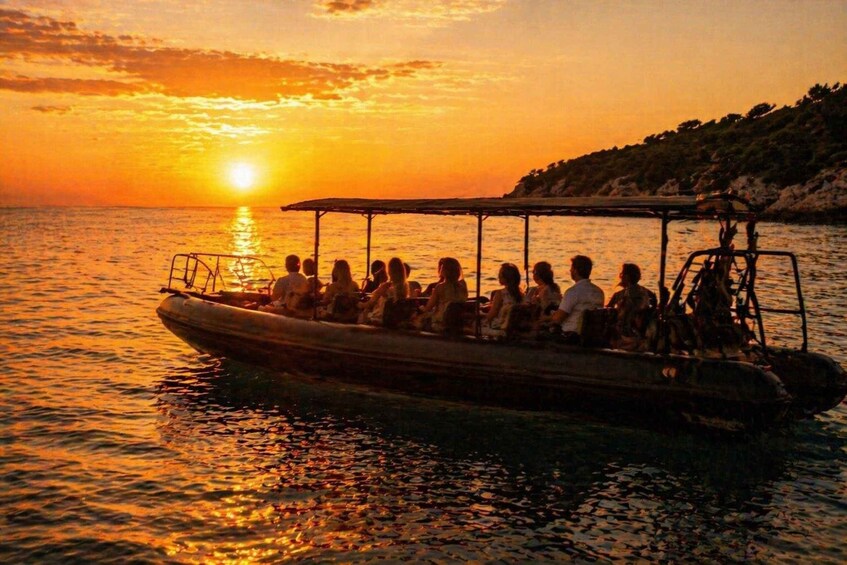 A boat with people on a calm sea during sunset. 4