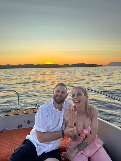 A couple on a boat with a sunset in the background. 2