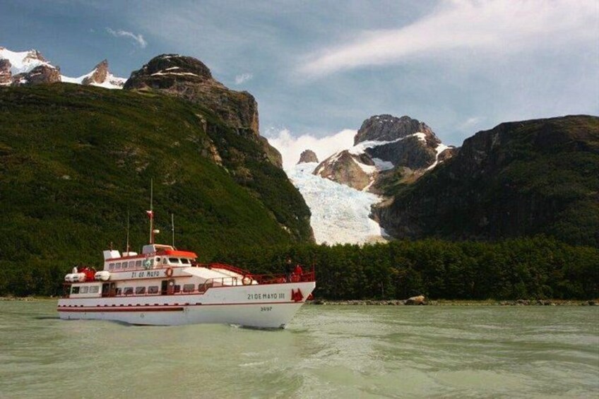 A boat named '21 de Mayo' near a glacier with mountains in the background. 5