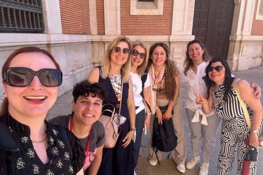 A group of people posing in front of a building with classical architecture. 5