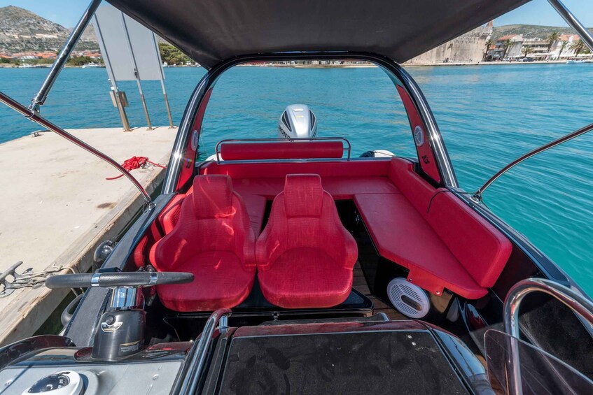 A boat's interior with red seats and a steering wheel. 1