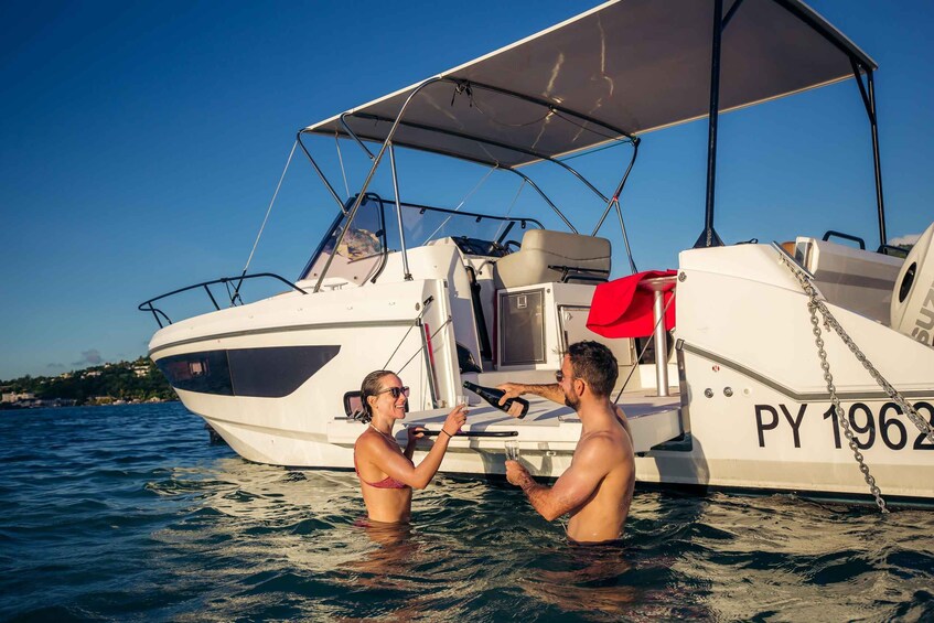A couple on a boat with a canopy, surrounded by water. 3