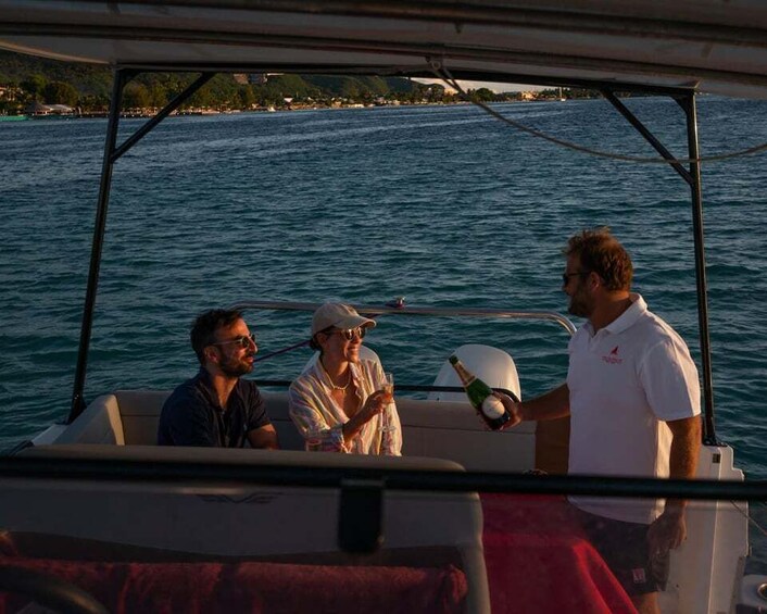 A boat with three people on board, one holding a bottle. 1