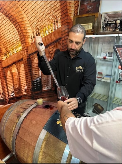A person pouring wine from a bottle into a glass. 2