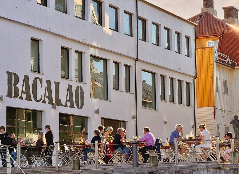A building with 'BACALAO' signage and people dining outside. 4