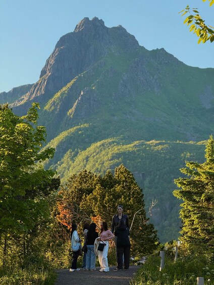 A group of people standing on a path with a mountain in the background. 3