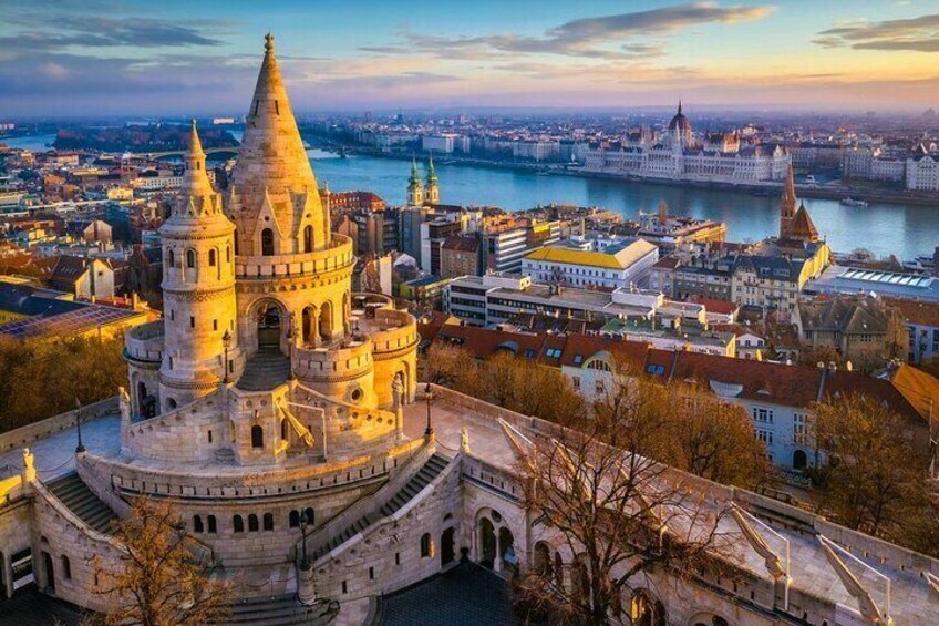 A historic building with a conical roof, surrounded by a cityscape with a river and modern buildings in the background. 3