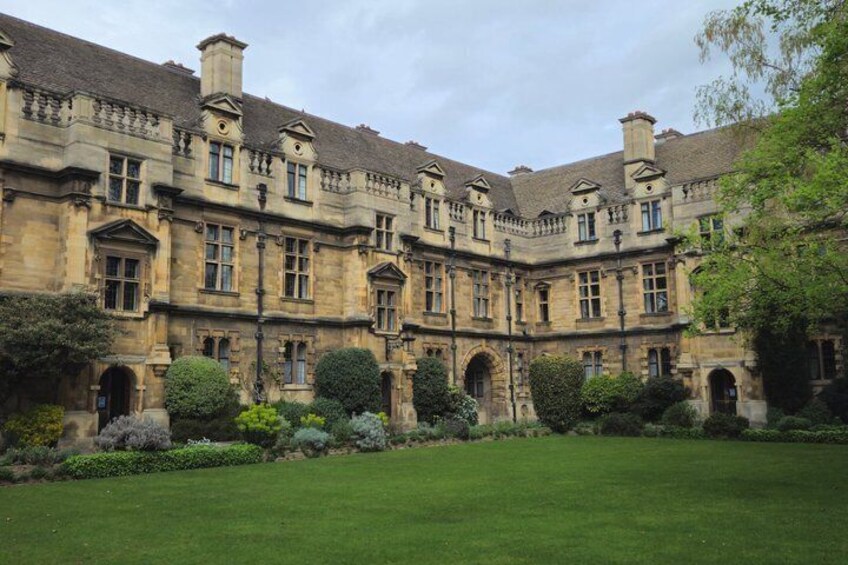 A historic building with a symmetrical facade, arched windows, and a well-manicured lawn. 3