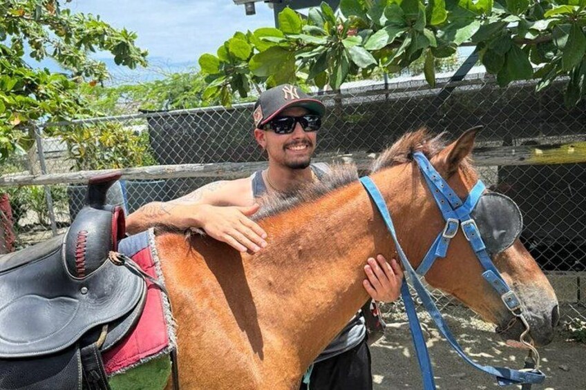 A person with a horse in a fenced area with trees and a body of water in the background. 5