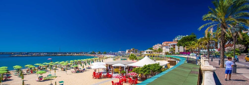 A beach with umbrellas, chairs, and a promenade. 2