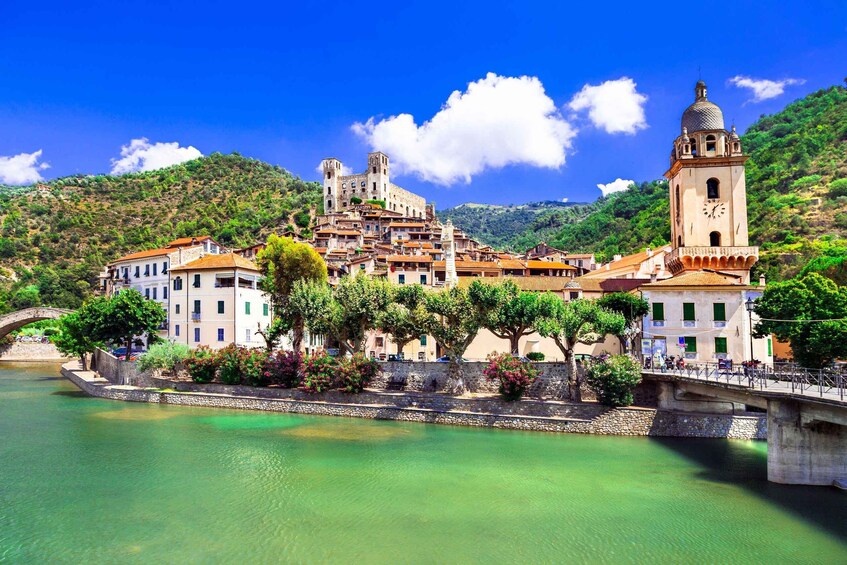 A historic town with a river, a bridge, and a hill with a castle-like structure. 1