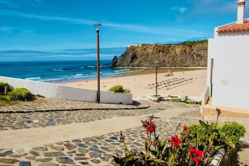 A coastal pathway leading to a beach with a rocky cliff in the background. 2