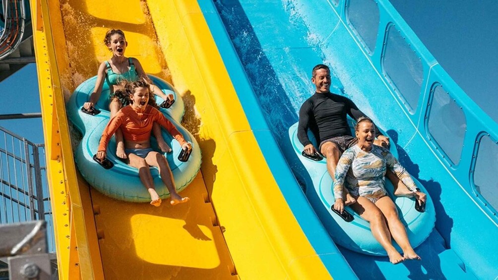 People on water slides with yellow and blue sections. 1