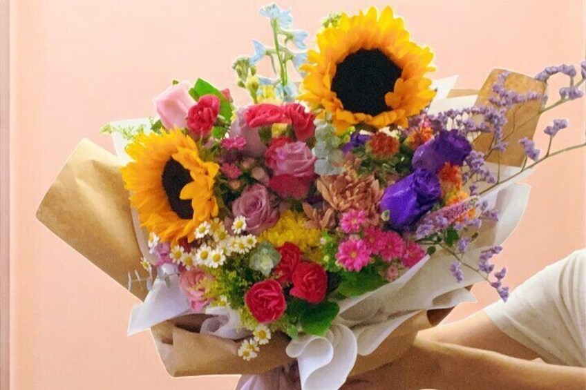 A bouquet of flowers with sunflowers, roses, and other colorful blooms. 3