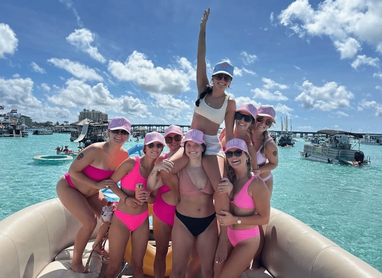 A group of people on a boat in a coastal area with clear skies and a pier in the background. 4