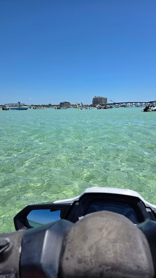 A clear blue sea with boats and a pier in the distance. 5
