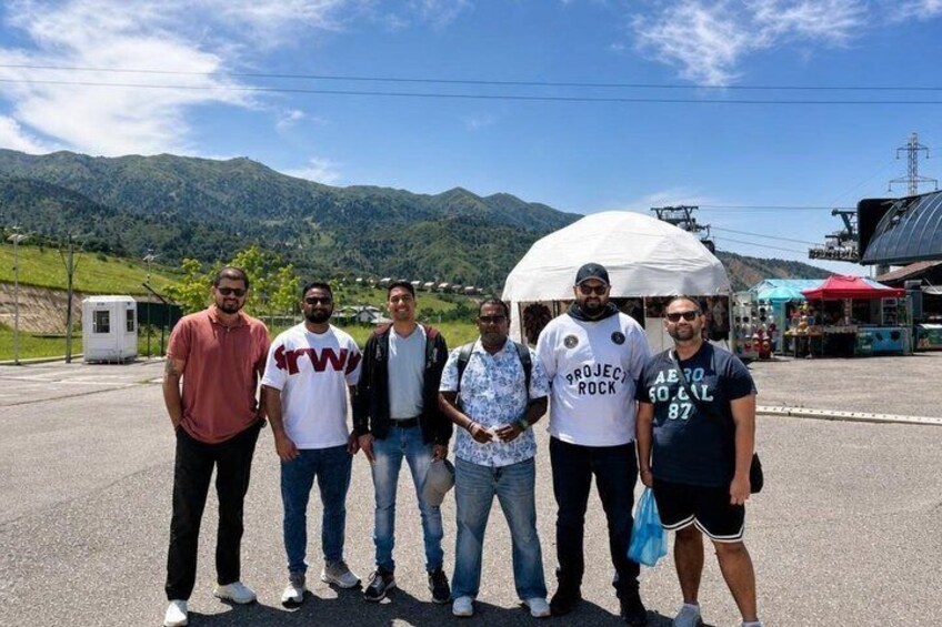A group of people standing in a parking lot with mountains in the background. 3