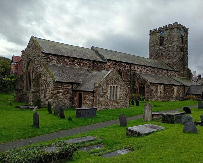 A historic church with a tower and a graveyard. 4