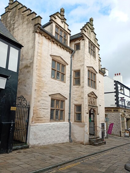 A historic building with ornate windows and a black gate. 3