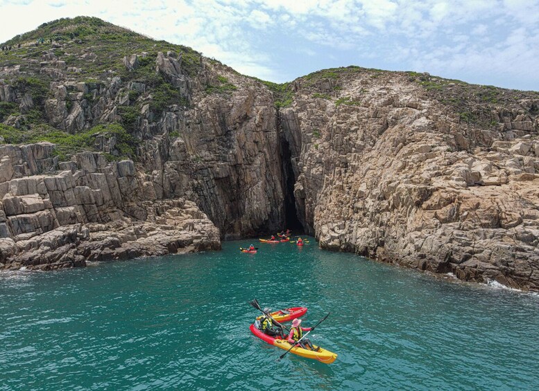 Kayakers navigating through a narrow waterway flanked by rocky cliffs. 4