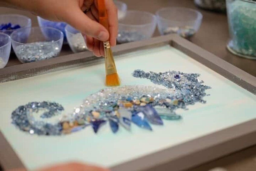 A person arranging sequins on a surface. 1