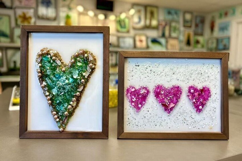 Two framed heart-shaped art pieces, one green and one pink, displayed on a counter. 5
