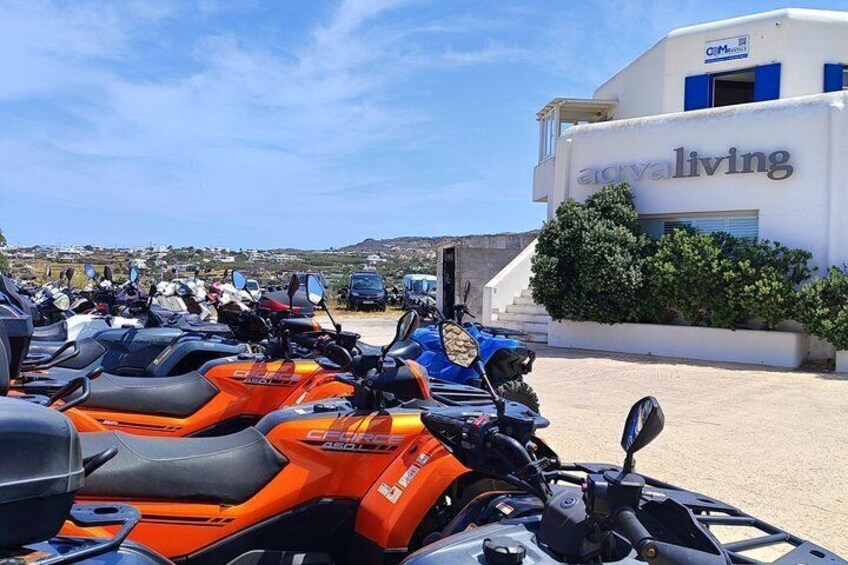 A row of ATVs parked in front of a building with 'ac val living' signage. 1