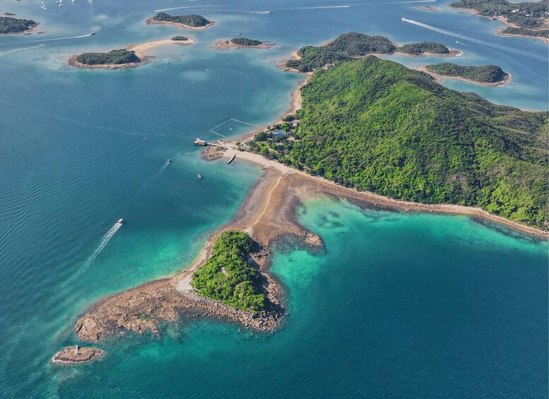 An aerial view of a coastal area with clear turquoise waters, a sandy beach, and a forested island. 3