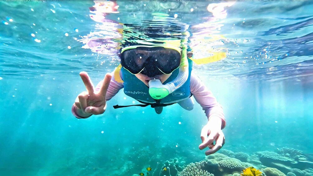 A person underwater making a peace sign. 1