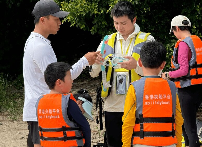 A group of people wearing life jackets and safety vests, gathered outdoors, possibly for a training or safety demonstration. 2
