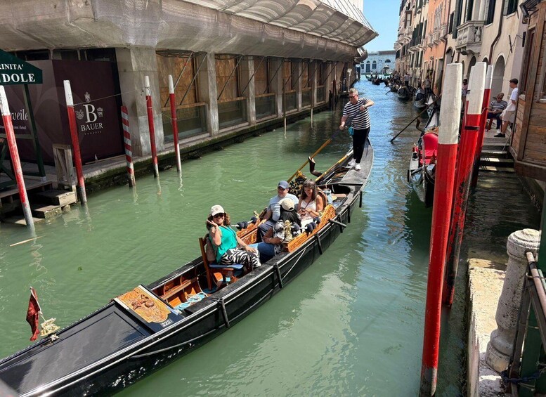 A gondola on a canal in Venice, Italy, with passengers and a gondolier. 2