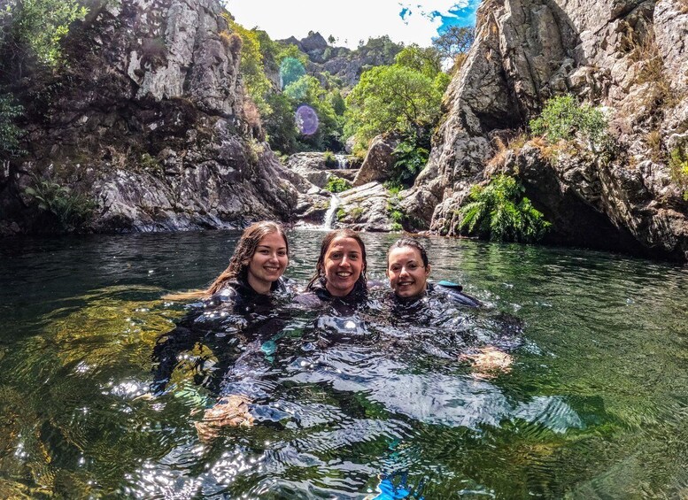 Three people in a river surrounded by rocky cliffs. 5
