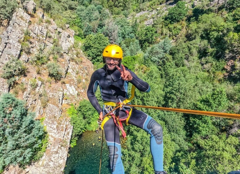 A person bungee jumping from a cliff with dense forest below. 4