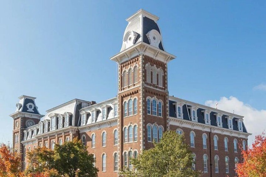 A large brick building with arched windows and a clock tower. 5