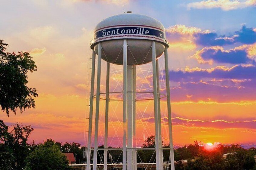 A water tower labeled 'Bentonville' with a sunset in the background. 3