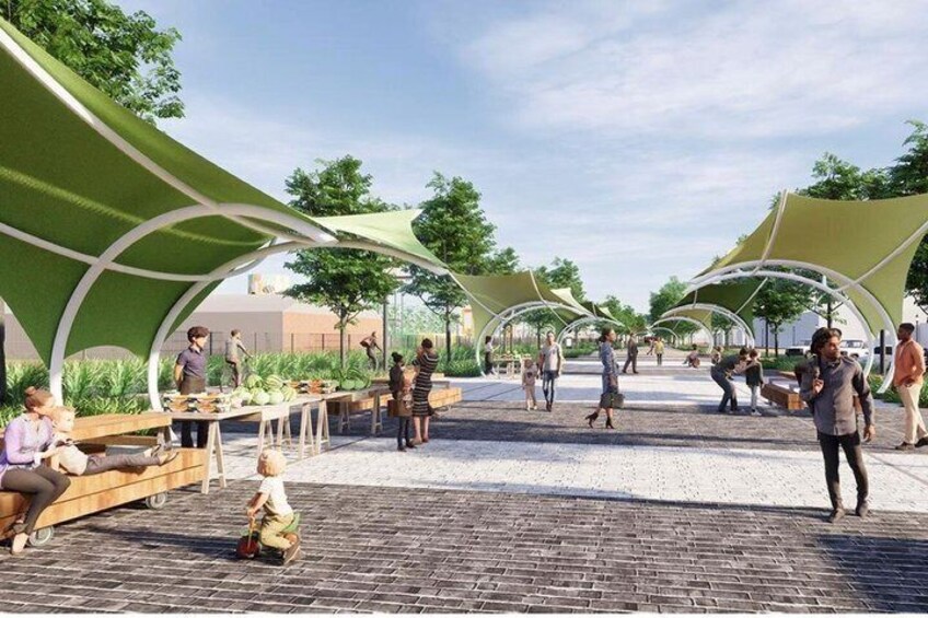 An outdoor market with people shopping and sitting under green canopies. 3