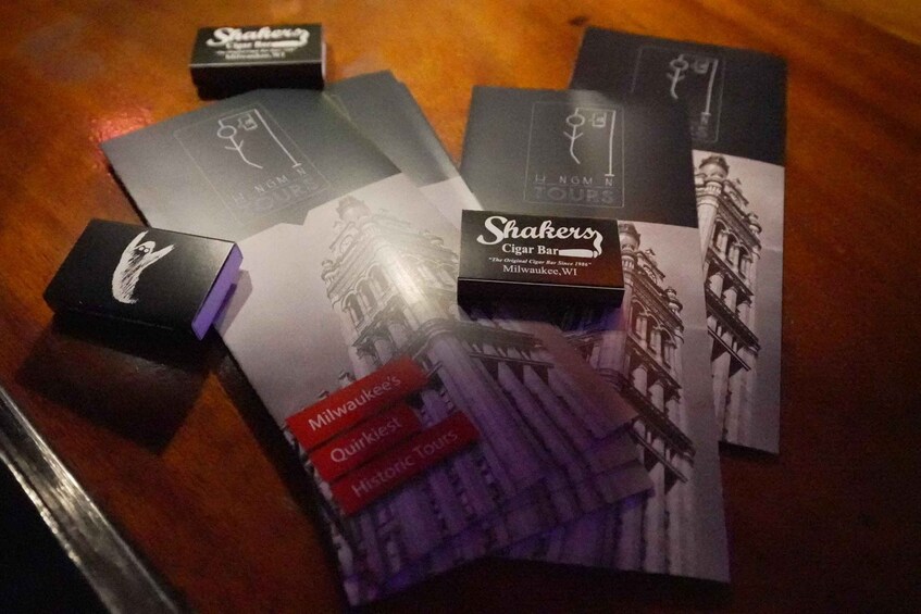A collection of Shaker's cigar bar promotional materials, including a box and several brochures with architectural imagery. 1