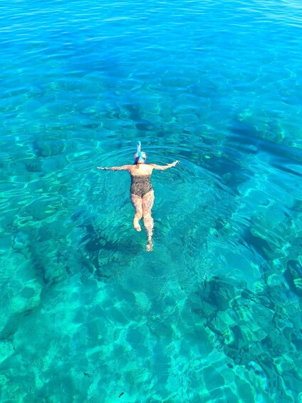 A person swimming in clear blue water. 1